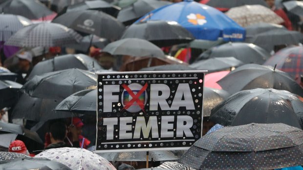 Demonstrators march against Brazil's President Michel Temer, holding banners reading "Temer Out", in Sao Paulo, on Sunday.