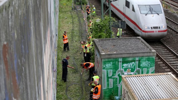 Police officers lay barbed wire on the edge of train tracks near the Convention Centre in Hamburg in preparation for the upcoming G20 Summit. 