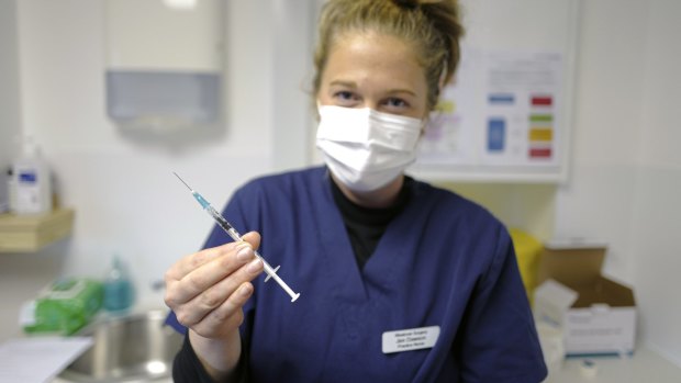 A nurse holds a dose of a COVID-19 vaccine at the Falmouth Health Centre in the UK.
