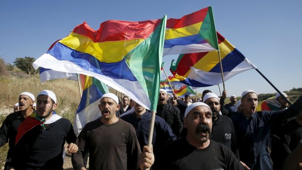 Druze men march towards the border fence between Syria and the Israeli-occupied Golan Heights, near the Druze village of Majdal Shams.