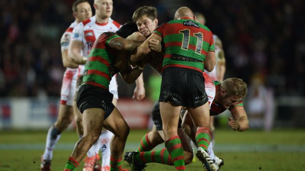 Wrapped up: Louie McCarthy-Scarsbrook is tackled by Glenn Stewart, Issac Luke and Tom Burgess during South Sydney's 39-0 win over St Helens in February's World Club Challenge final.
