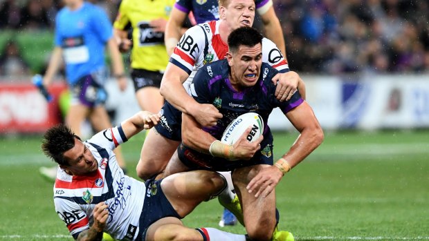 Near miss: Mitchell Pearce falls off the tackle with teammate Dylan Napa on Nelson Asofa-Solomona of the Storm.