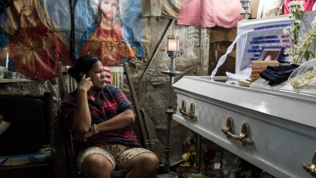 Kimberly Sailog watches over the coffin of her daughter, Christine Joy Sailog, 12, who was killed when an unidentified gunman shot at an alleged drug suspect, hitting the girl during the traditional Christmas dawn mass in a church.