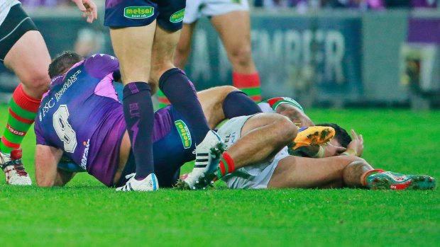 Cameron Smith of the Storm kicks Issac Luke while being tackled by David Tyrrell.