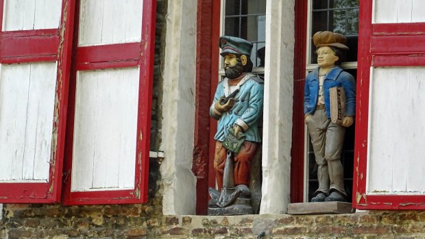 Carved wooden figures on a house in Bruges, Belgium.