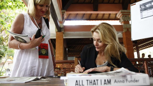 Author Anna Funder autographs her books at the Ubud Writers and Readers Festival in 2012. 
