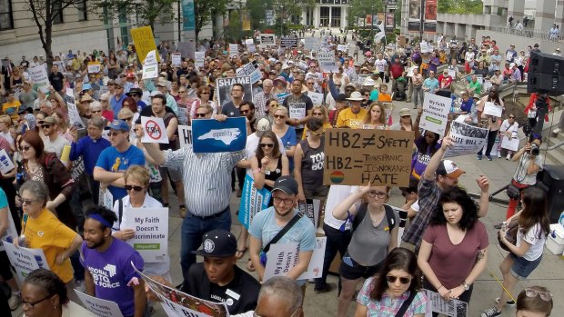 Marchers in North Carolina protest for and against a Republican-backed law curtailing protections for LGBT people and limiting public bathroom access for transgender people.