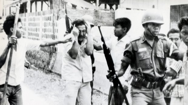 A Chinese student (centre) is pummelled by Indonesian youths who stormed the dormitory of a communist Chinese University in Jakarta in 1965.