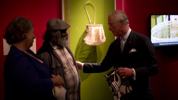 Prince Charles receives a gift from basket maker Abe Muriata, centre, as he visits the "Indigenous Australia: Enduring Civilisation" exhibition at the British Museum.