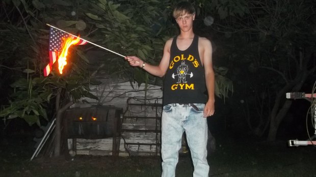 This undated photo appears to show Dylann Roof burning the US flag. 