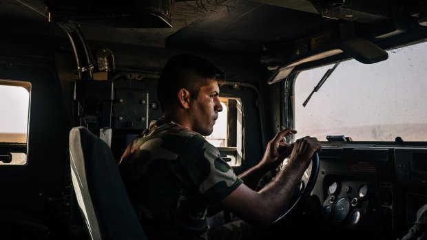 An Iraqi army soldier drives a Humvee in the outskirts of Kabrouk in May.