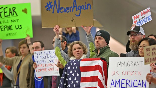 People chant slogans at Indianapolis International Airport on Sunday.