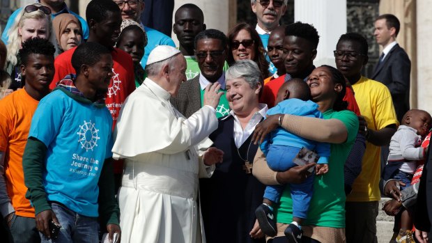 Pope Francis meets a group of migrants, during his weekly general audience, at the Vatican.