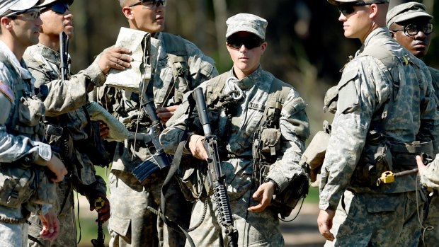 A female Army Ranger stands with her unit during Ranger School at Camp Rudder on Eglin Air Force Base, Florida. 