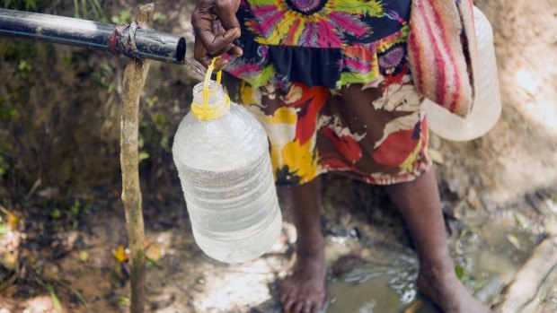 A woman fetches water from Kanma village's last remaining supply. The village has a population of 270. 