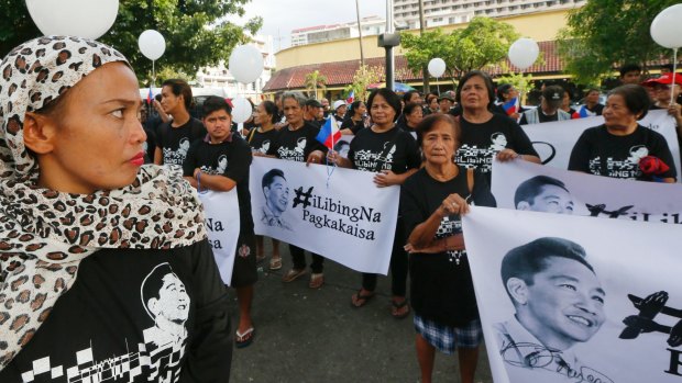 Supporters of the late Philippine dictator Ferdinand Marcos display his images prior to marching on Monday.