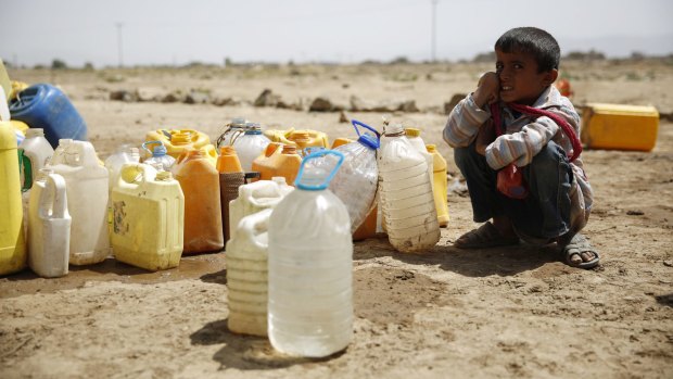 A boy waits for his turn to fill buckets with water from a public tap amid an acute shortage of water in Sanaa. 