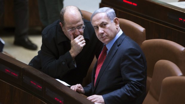 Israeli Prime Minister Benjamin Netanyahu listens to party colleague and Defence Minister Moshe Yaalon during a session of Israel's parliament on Monday.