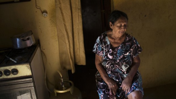 Terezinha de Melo, 75, who said she has chikungunya and suffers joint pain and headaches, in her home as municipal health agents inspect it during a fumigation campaign to kill Aedes aegypti mosquitoes in Monteiro, Brazil.