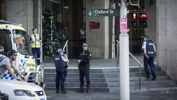 Police are seen inside and outside of a building on the corner of Wentworth avenue and Oxford street in Sydney.