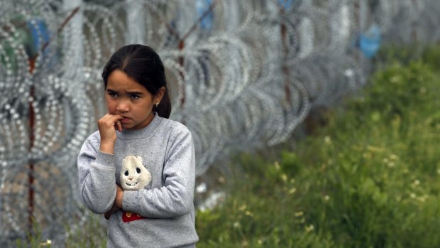 A girl walks by a border fence near Serbia's Horgos border crossing into Hungary.