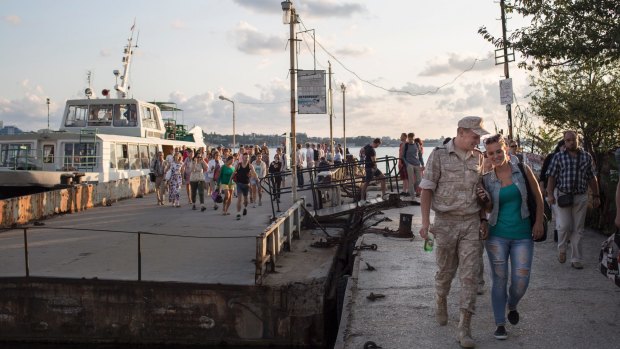 A Russian officer and his girlfriend disembark from a ferry in Sevastapol, in Russian-occupied Crimea, last year.