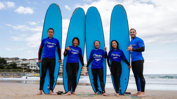 China beach: Tourists (from left) Yuchen Wang, Seiyu Shu, Xiaoling Yang, Xiaodan Zhang and with Bondi's Let's Go Surfing coach Will Bigelow.