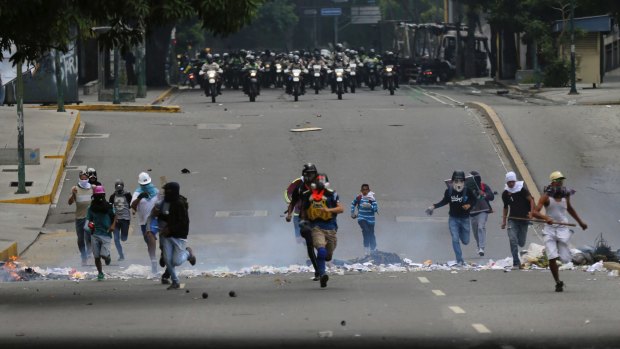 Demonstrators run from advancing security forces who prevented the demonstrators from marching to the office of Attorney General Luisa Ortega Diaz.