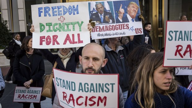 Protesters hold anti-Trump signs outside a conference in Washington, DC.