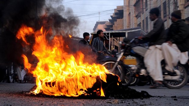 Public outrage: Tyres burn during a protest in Karachi.