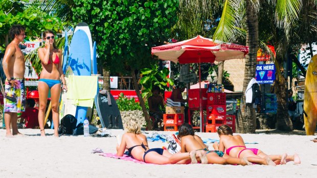 Tourists relax on Kuta Beach.