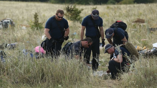 AFP officers and their Dutch counterparts collect human remains from the MH-17 crash site.