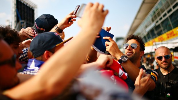 Daniel Ricciardo of Australia and Red Bull Racing signs autographs for fans.