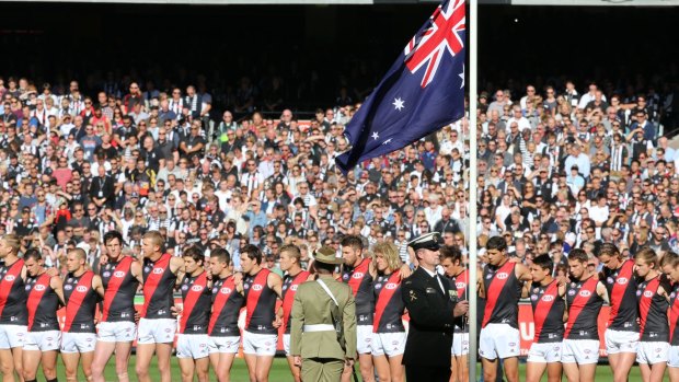 Special occasion: The Australian flag is taken to half-mast before the Essendon-Collingwood match at the MCG. 