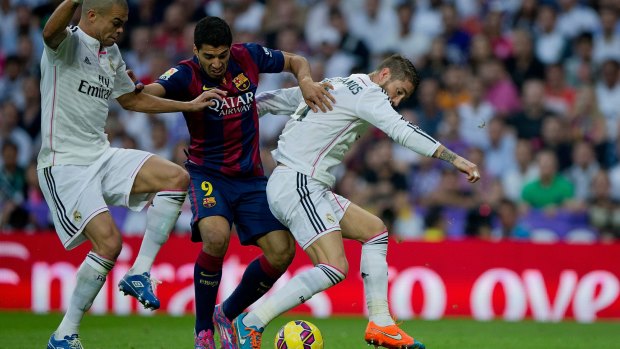 Luis Suarez tangles with Madrid defenders Pepe (L) and Sergio Ramos.