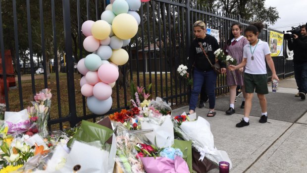 Students and parents place flowers outside Banksia Road Public School in Greenacre where two boys were killed.