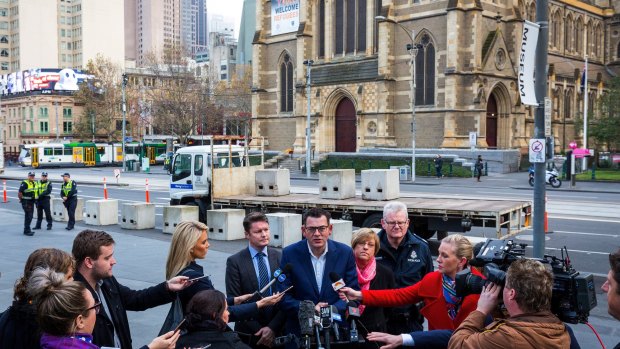 Premier Daniel Andrews speaks to the media as concrete bollards are installed at Federation Square in June.