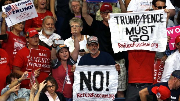 Protesters hold up signs during a Trump rally in Ohio on July 25.