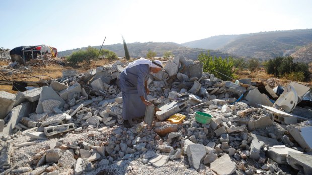 A Palestinian inspects the rubble of a family home demolished by Israeli troops in the occupied West Bank village of Sair, near Hebron, in August.