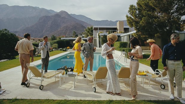 The beautiful people: Former fashion model Helen Dzo Dzo Kaptur (in white lace), Nelda Linsk (in yellow), wife of art dealer Joseph Linsk, and other guests at the Kaufmann Desert House in Palm Springs, California, January 1970. 