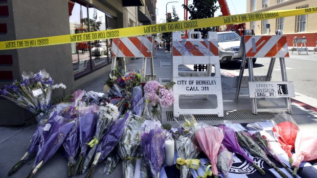 Flowers are laid at a memorial near the scene of a fourth-storey apartment building balcony collapse.