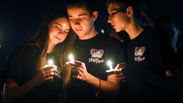Attendees comfort each other at a candlelight vigil for the victims of the shooting at Marjory Stoneman Douglas High School in Parkland, Florida.