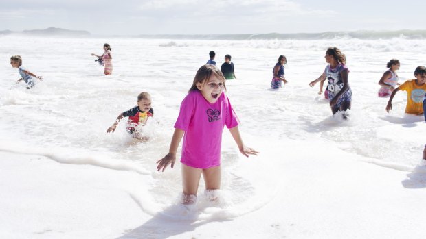 Foamy frolic: Children from Brewarrina in rural NSW take to the waves at Narrabeen.