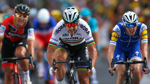 Peter Sagan (centre), crosses the finish line ahead of Daniel Martin (right) and BMC's  Greg van Avermaet (left).