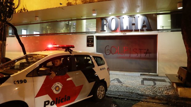Police guard the Folha de SPaulo newspaper that had its facade vandalized during a protest against Brazil's President Michel Temer in Sao Paulo on Wednesday.