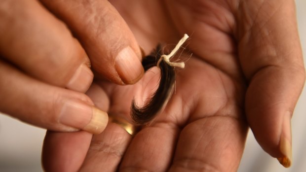 Reginald Mullaly's sister Dawn holds a lock of his hair.