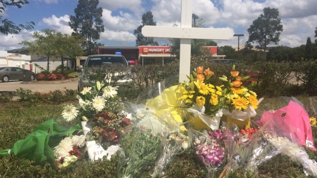 Flowers laid outside Hungry Jack's in Hoxton Park, where Courtney Topic was shot dead. 
