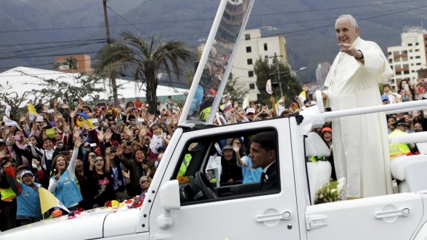 Pope Francis greets the faithful from a popemobile in Quito on Sunday.