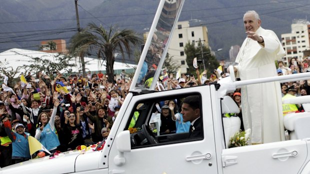 Pope Francis greets the faithful from a popemobile in Quito on Sunday.