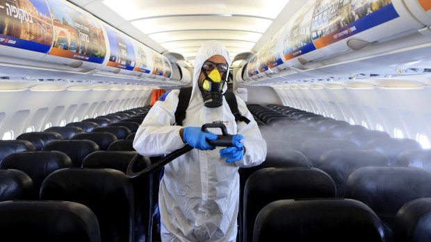 A maintenance worker disinfects an aircraft at Ben Gurion Airport in Tel Aviv, Israel. Despite its high vaccination rates, Israel has shut its doors to tourists.